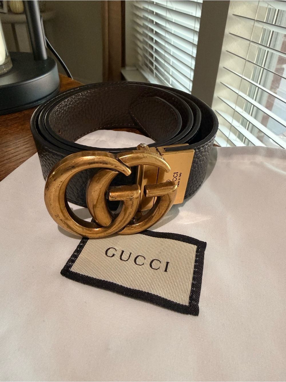 Gucci black leather belt featuring the iconic interlocking GG gold tone buckle